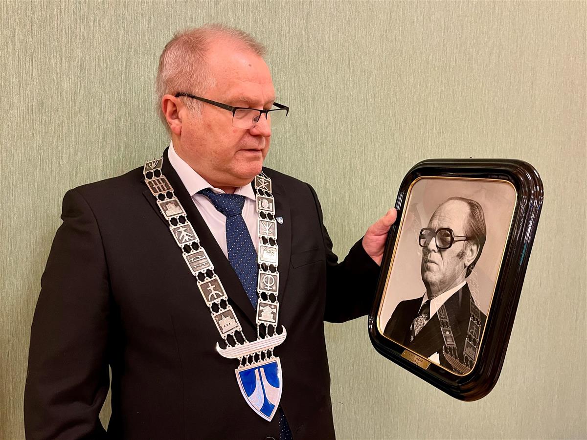 Fungerande ordførar Bjarne Kvalsvik ser på eit bilde av tidlegare ordførar Knut Nærø.  - Klikk for stort bilete